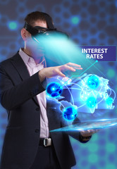 Business, Technology, Internet and network concept. Young businessman working in virtual reality glasses sees the inscription: Interest rates