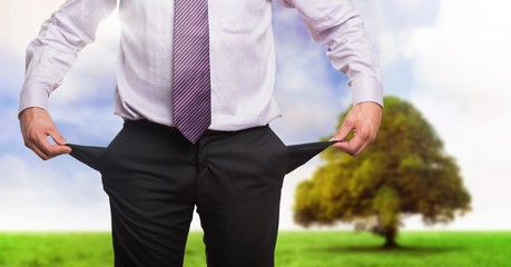 Businessman with empty pockets in nature
