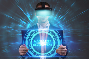 Business, Technology, Internet and network concept. Young businessman working in virtual reality glasses sees the inscription: Mobile apps development