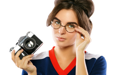 Woman model in vintage look holding retro camera in her hands