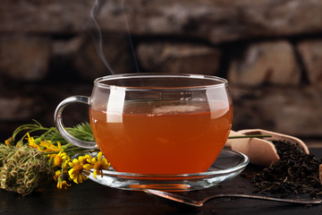 A cup of tea with tea leaves. Tea among the herbs.