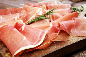 Italian prosciutto crudo or jamon with rosemary. Raw ham.