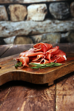 Italian prosciutto crudo or jamon with rosemary. Raw ham.
