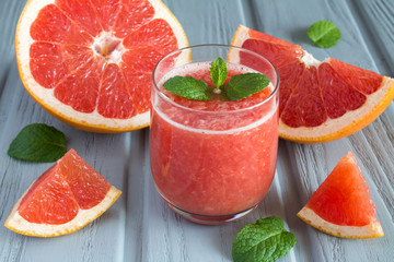 Grapefruit smoothie on the grey wooden background