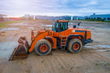 Orange loader bulldozer in the mud