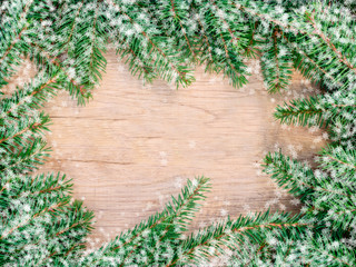 fir branches on texture wood background, top view