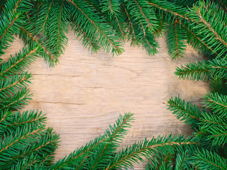 fir branches on texture wood background, top view
