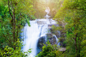 Waterfall in rain forest with flare of sun light at Sirithan waterfall,Chiangmai, Thailand