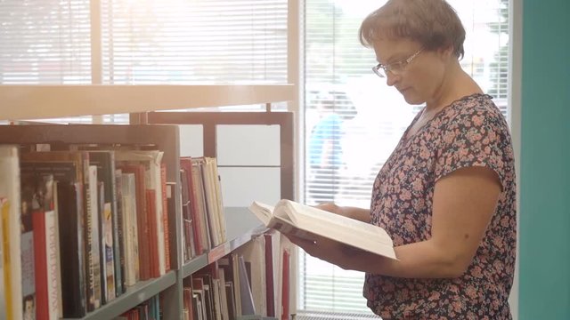Woman reading book in library