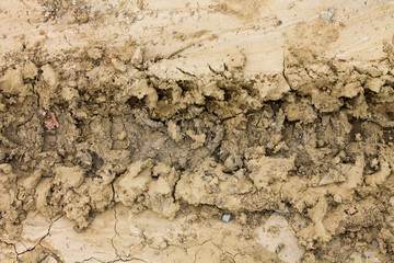 Dried earth excavated. Thumbnail of a tractor seen from above.