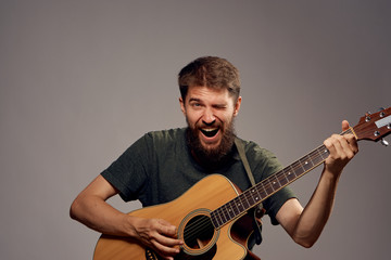 man holding a guitar on a black background, emotions