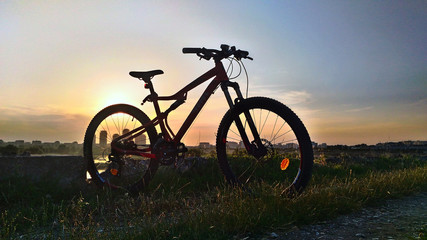 Naklejka na ściany i meble Mountain bike silhouette at sunset