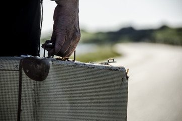 Old woman going with her suitcase on the road waiting for the third age