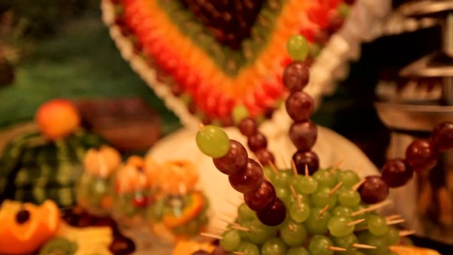 Fourchette sweet table with fruit on a background of colorful tapestry. wedding day