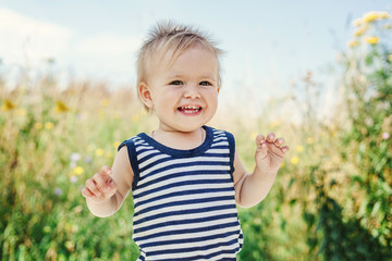 Funny little boy one year old, joyful summer portrait