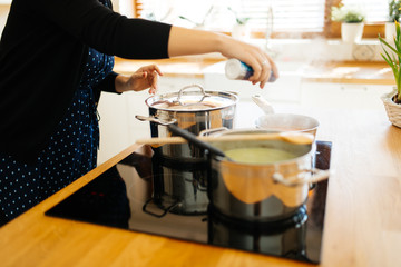 Woman adding spices to food
