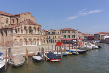 Church of San Donato in Murano, in front of a row of moored boats, Venice, Italy
