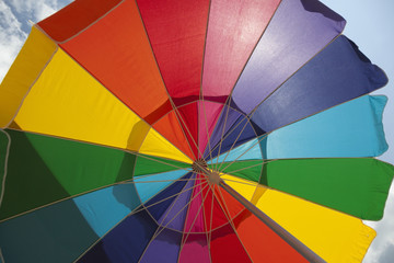Looking up into colorful backlit beach umbrella.
