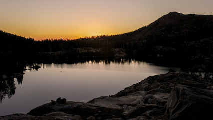 Sunrise at he Sierra Nevada near Island Lake, California, featuring the rugged terrain and warm light, to illustrate the concept of adventure in the outdoors 