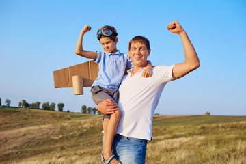 Obraz premium Father and son show muscles in nature.Father's Day.