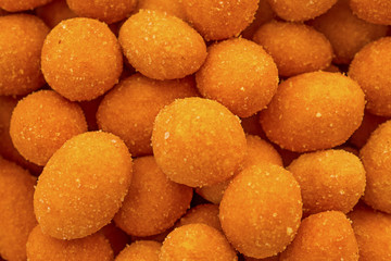 Crispy chilli peanuts snacks macro close up. Orange peanuts for background