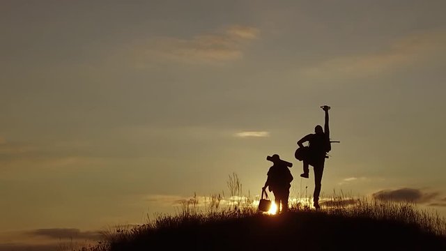 tourists jump joy. two people running around jumping for joy on the mountain silhouette travel slow motion video