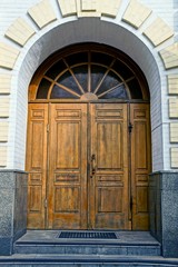Старая коричневая деревянная дверь на фасаде...