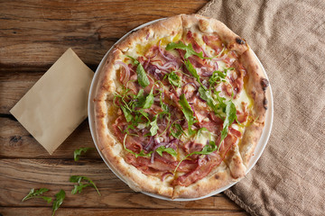 Italian pizza with bacon, broom, onion and cheese.