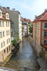Fototapeta na wymiar Bridge, old colorful buildings and water canal on the Kampa Island in Prague, Czech Republic, on a sunny day.