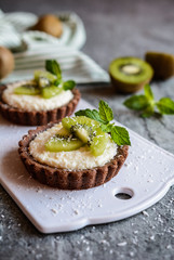 Chocolate tartlets filled with coconut cream and topped with kiwi slices