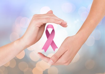 Open hands with pink ribbon for breast cancer awareness