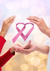 Open hands together with pink ribbon for breast cancer awareness