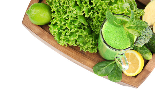 Glass of green healthy juice with ingredients on white background