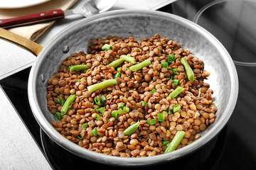 Frying pan with lentils on electric stove