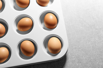 Muffin tin with hard boiled eggs on table