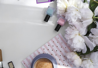 Bouquet of beautiful peony flowers, cup of coffee and cosmetics on light table
