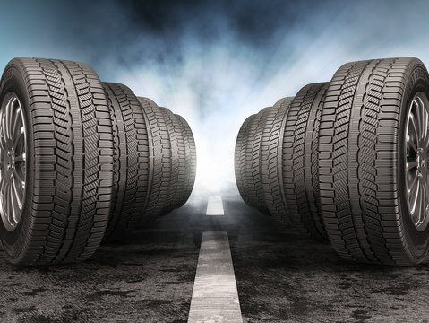 Car tires standing on the road against light of headlights.