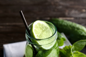 Delicious refreshing water with mint and cucumber in glass jar, closeup