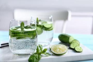 Delicious refreshing water with mint and cucumber in glass on table