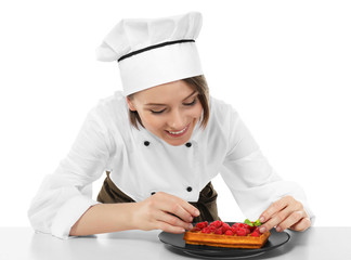 Female chef with tasty dessert on white background