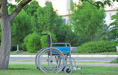 Fototapeta premium Wheelchair in green park. Elderly care concept