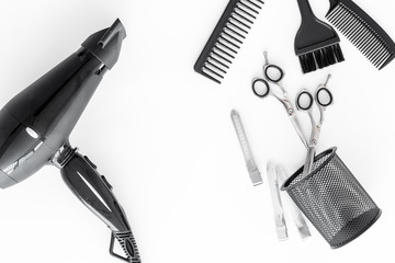 hairdresser working desk with tools for hair styling on white desk background top view