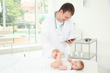 Doctor using tablet and baby in hospital