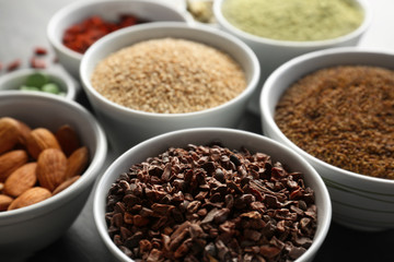 Composition with assortment of superfood products in bowls, closeup