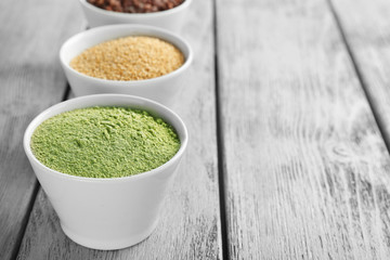Composition with assortment of superfood products in bowls on wooden background