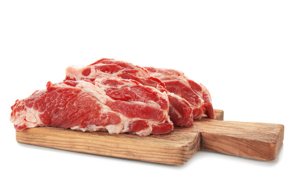 Wooden board with fresh raw meat on white background
