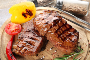 Tasty grilled steaks on wooden board
