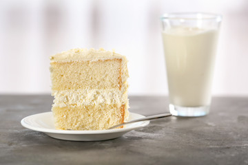 Piece of delicious vanilla cake on table