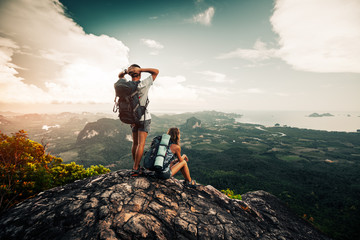 Two hikers relax on top of a mountain with great view