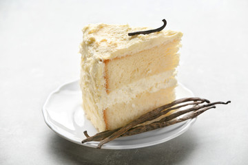 Piece of delicious vanilla cake on table